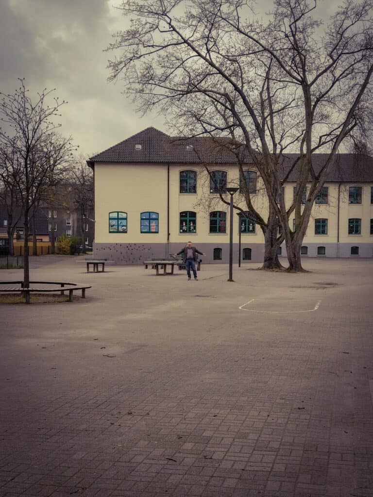Schulleiter Markus Hogrebe alleine auf dem Schulhof der GEsamtschule Horst