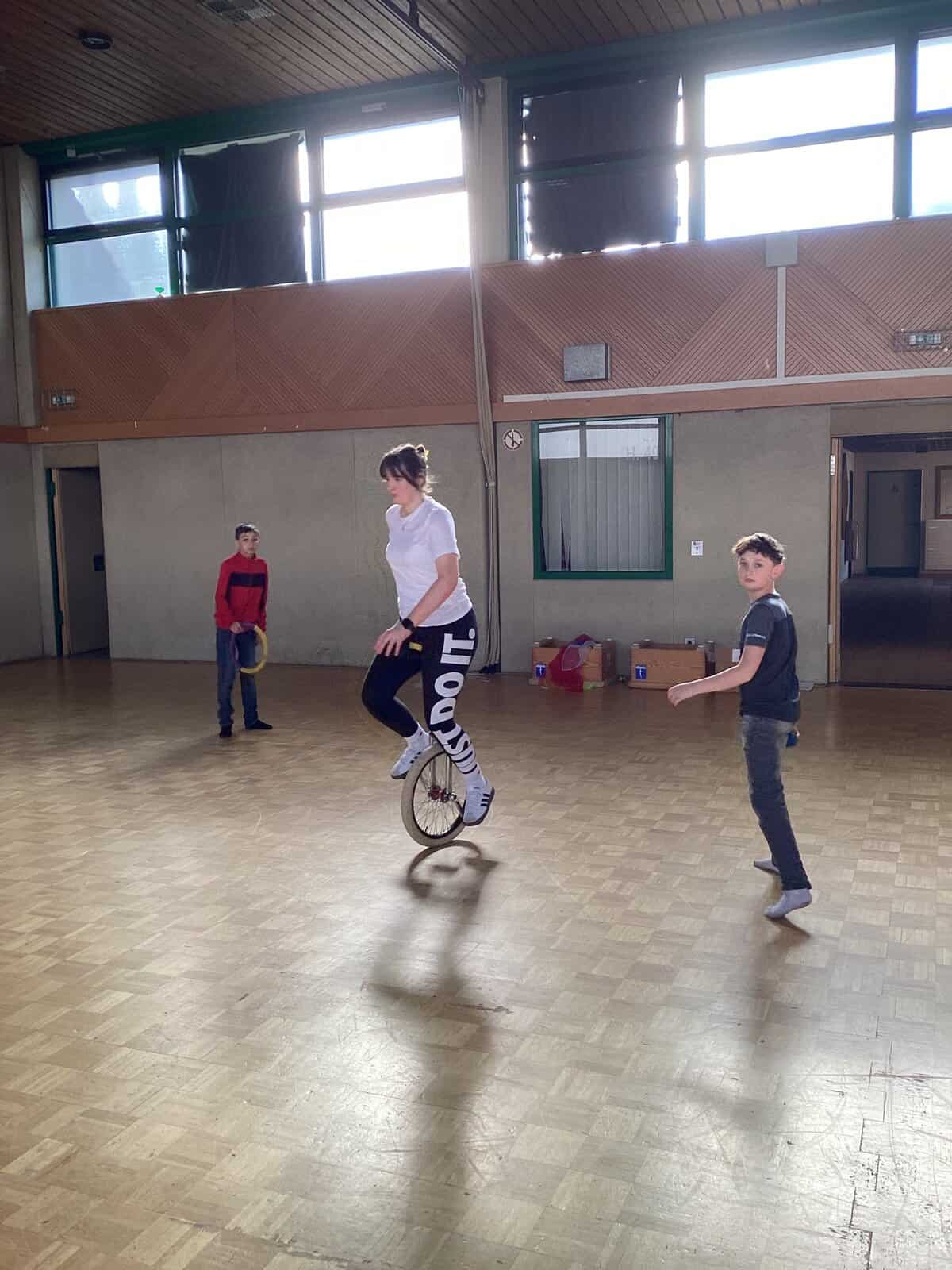 Schülerin auf dem Einrad in der Sporthalle
